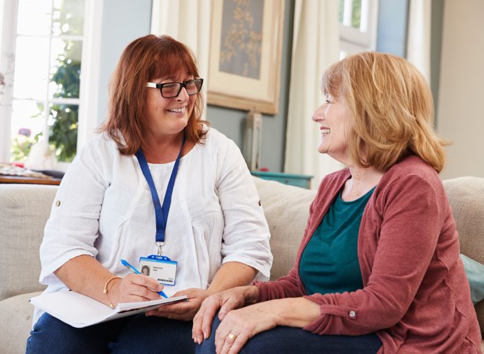 Carer listening to an individual and taking notes