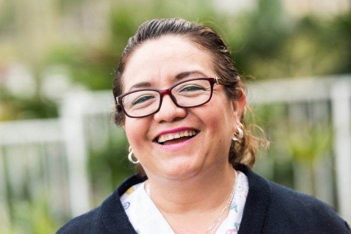 Middle aged women wearing glasses, looking at camera and smiling