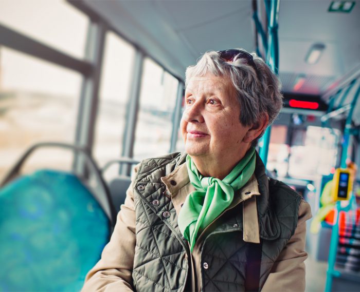 Female pensioner comfortably sitting at front of bus